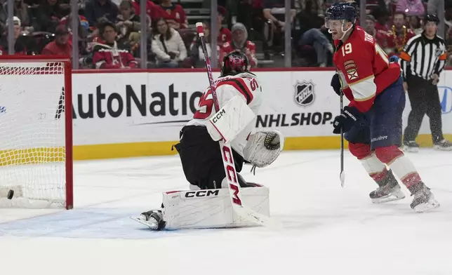 Florida Panthers left wing Matthew Tkachuk (19) watches as the puck gets past New Jersey Devils goaltender Jacob Markstrom, left, on a goal scored by Florida Panthers center Sam Reinhart, not shown, during the second period of an NHL hockey game, Tuesday, Nov. 12, 2024, in Sunrise, Fla. (AP Photo/Lynne Sladky)