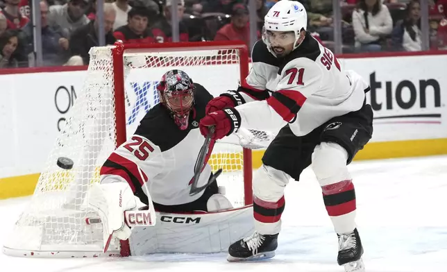 New Jersey Devils goaltender Jacob Markstrom (25) and defenseman Jonas Siegenthaler (71) defend the goal during the second period of an NHL hockey game, against the Florida Panthers, Tuesday, Nov. 12, 2024, in Sunrise, Fla. (AP Photo/Lynne Sladky)