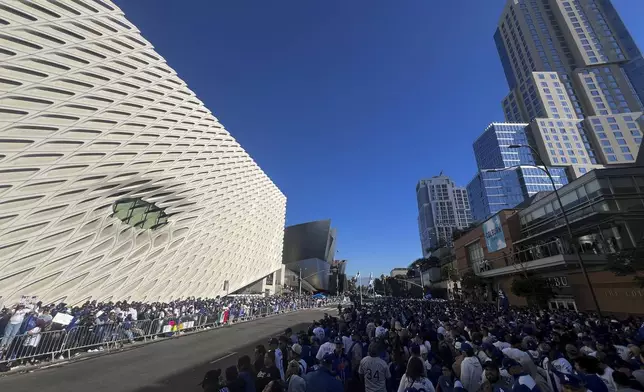 Fans crowd the sidewalk as they wait for the start of the Los Angeles Dodgers baseball World Series championship parade Friday, Nov. 1, 2024, in Los Angeles. (AP Photo/Kyusung Gong)