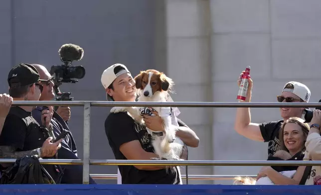 Los Angeles Dodgers' Shohei Ohtani holds his dog Decoy during the Los Angeles Dodgers baseball World Series championship parade Friday, Nov. 1, 2024, in Los Angeles. (AP Photo/Jae C. Hong)