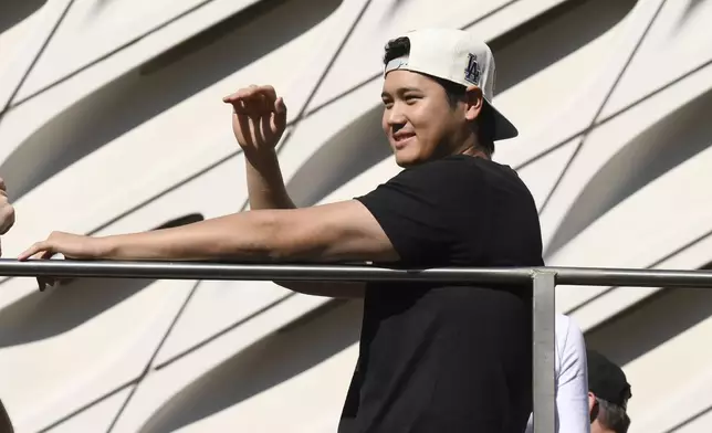 Los Angeles Dodgers' Shohei Ohtani waves at fans during the baseball team's World Series championship parade Friday, Nov. 1, 2024, in Los Angeles. (AP Photo/Kyusung Gong)