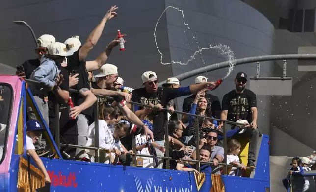 Los Angeles Dodgers players celebrate with fans during the baseball team's World Series championship parade Friday, Nov. 1, 2024, in Los Angeles. (AP Photo/Kyusung Gong)