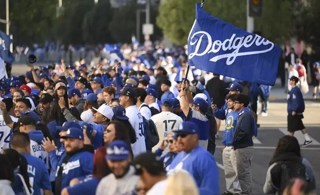 Fans crowd behind barricades waiting for the start of the Los Angeles Dodgers baseball World Series championship parade Friday, Nov. 1, 2024, in Los Angeles. (AP Photo/Kyusung Gong)