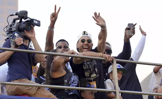 Los Angeles Dodgers' Mookie Betts waves at fans during the Los Angeles Dodgers baseball World Series championship parade Friday, Nov. 1, 2024, in Los Angeles. (AP Photo/Jae C. Hong)