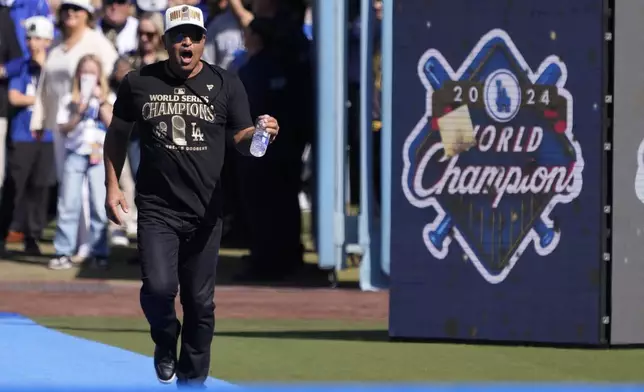 Los Angeles Dodgers manager Dave Roberts celebrates as he walks to the stage during the baseball team's World Series championship parade and celebration at Dodger Stadium, Friday, Nov. 1, 2024, in Los Angeles. (AP Photo/Mark J. Terrill)