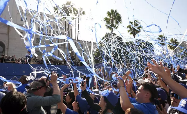 Fans cheer as buses carrying players are driven past during the Los Angeles Dodgers baseball World Series championship parade Friday, Nov. 1, 2024, in Los Angeles. (AP Photo/Jae C. Hong)