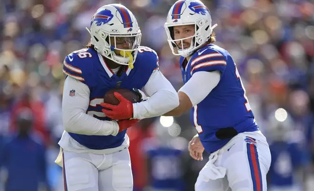 Buffalo Bills quarterback Josh Allen, right, hands off to running back Ty Johnson (26) during the first half of an NFL football game against the Miami Dolphins, Sunday, Nov. 3, 2024, in Orchard Park, N.Y. (AP Photo/Adrian Kraus)