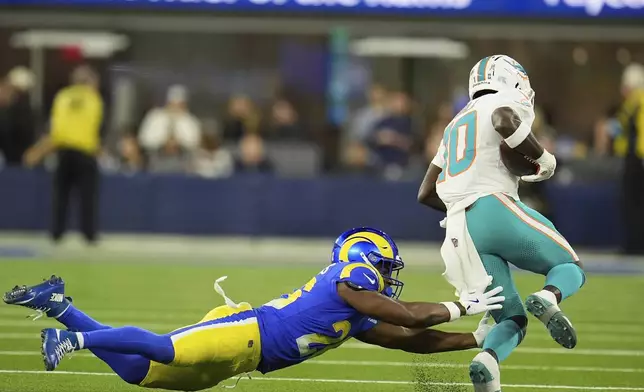 Miami Dolphins wide receiver Tyreek Hill, right, escapes a tackle by Los Angeles Rams safety Kamren Kinchens during the first half of an NFL football game, Monday, Nov. 11, 2024, in Inglewood, Calif. (AP Photo/Marcio Jose Sanchez)
