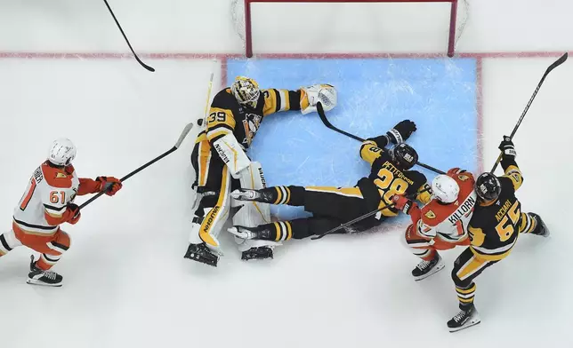 Pittsburgh Penguins goaltender Alex Nedeljkovic (39) makes a second save on the Anaheim Ducks' Cutter Gauthier (61) late in the third period of an NHL hockey game Thursday Oct. 31, 2024 in Pittsburgh. (Chaz Palla/Pittsburgh Tribune-Review via AP)