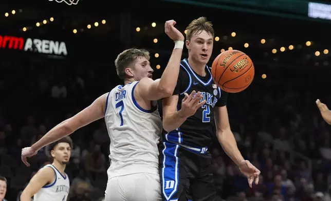 Duke guard Cooper Flagg (2) passes as Kentucky forward Andrew Carr (7) defends during the second half of an NCAA college basketball game, Tuesday, Nov. 12, 2024, in Atlanta. (AP Photo/John Bazemore )