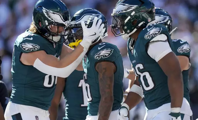 Philadelphia Eagles wide receiver DeVonta Smith, center, celebrates with teammates after catching a long touchdown pass from quarterback Jalen Hurts during the second half of an NFL football game against the Cincinnati Bengals, Sunday, Oct. 27, 2024 in Cincinnati. (AP Photo/Carolyn Kaster)