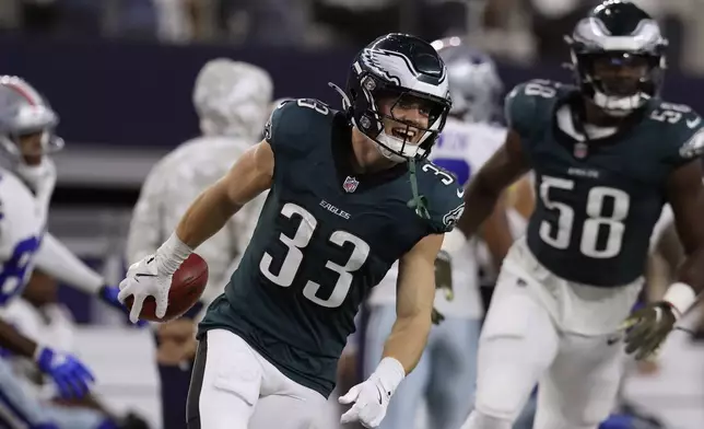 Philadelphia Eagles' Cooper DeJean (33) and Jalyx Hunt (58) celebrate a long punt return by DeJean in the second half of an NFL football game against the Dallas Cowboys in Arlington, Texas, Sunday, Nov. 10, 2024. (AP Photo/Gareth Patterson)