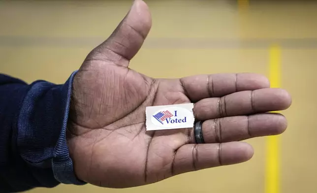 Sasha Dix shows his "I voted" sticker after he voted at TC Roberson High School on Election Day, Tuesday, Nov. 5, 2024 in Asheville, N.C. (AP Photo/Kathy Kmonicek)