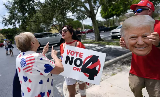 FILE - A supporter of Democratic presidential nominee Vice President Kamala Harris, left, argues about abortion rights with supporters of Republican presidential nominee former President Donald Trump, protesting alongside an event kicking off a national "Reproductive Freedom Bus Tour" by the Harris-Walz campaign, Tuesday, Sept. 3, 2024, in Boynton Beach, Fla. (AP Photo/Rebecca Blackwell,File)