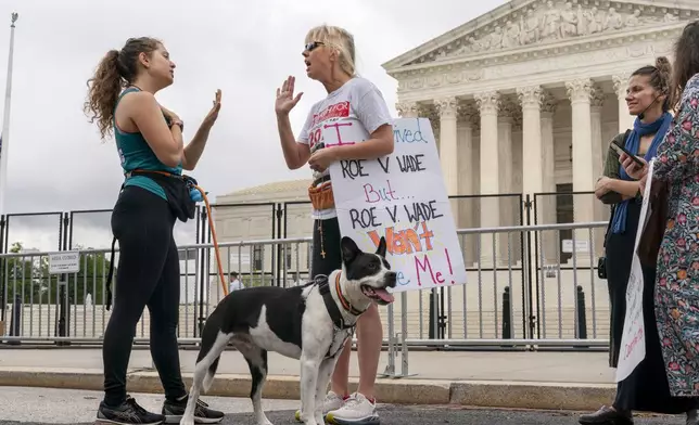 FILE - Lilo Blank, 23, of Philadelphia, left, who supports abortion rights, and Lisa Verdonik, of Arlington, Va., who is anti-abortion, talk about their opposing views on abortion rights, Friday, May 13, 2022, outside the Supreme Court in Washington, ahead of expected abortion rights rallies across the country on Saturday. (AP Photo/Jacquelyn Martin, File)