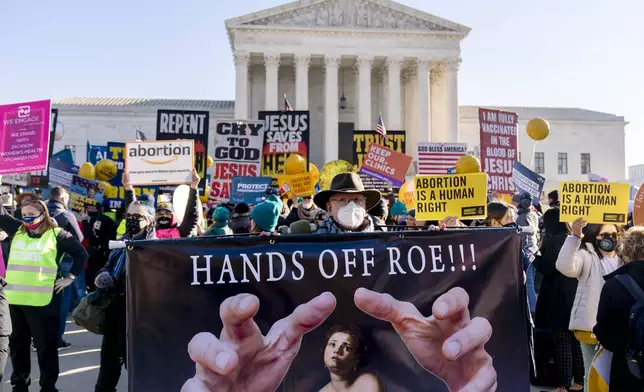 FILE - Stephen Parlato of Boulder, Colo., holds a sign that reads "Hands Off Roe!!!" as abortion rights advocates and anti-abortion protesters demonstrate in front of the U.S. Supreme Court, Wednesday, Dec. 1, 2021, in Washington. (AP Photo/Andrew Harnik, File)