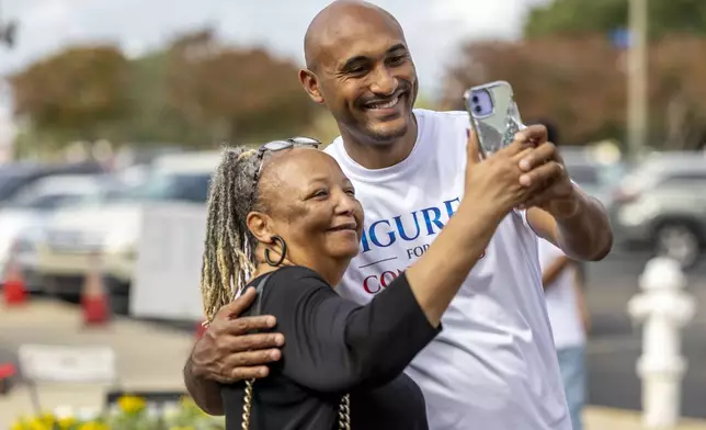 Shomari Figures, Democratic candidate for Alabama's 2nd congressional district, greets and takes a photo with Abbie Felder, of Montgomery, at the Frazer Church voting precinct, on Election Day, Tuesday, Nov. 5, 2024, in Montgomery, Ala. (AP Photo/Vasha Hunt)