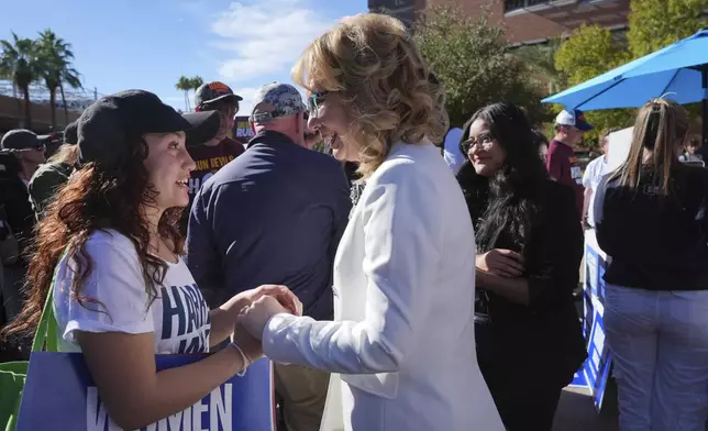 Former Arizona Democratic Rep. Gabby Giffords, right, talks with a supporter as she joined Arizona Democratic Senate candidate Rep. Ruben Gallego, D-Ariz., meeting with voters at Arizona State University on Election Day Tuesday, Nov. 5, 2024, in Tempe, Ariz. (AP Photo/Ross D. Franklin)