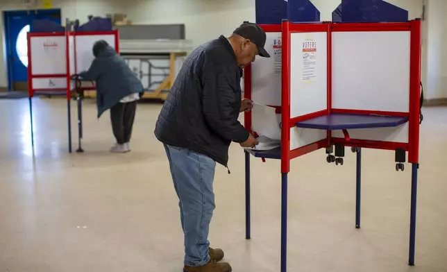 Voters mark their ballots at a polling station on the Navajo Nation in Fort Defiance, Ariz., on Election Day, Tuesday, Nov. 5, 2024. (AP Photo/Andres Leighton)