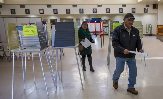 Voters look for the tabulation machine after marking their ballots at a polling station on the Navajo Nation in Fort Defiance, Ariz., on Election Day, Tuesday, Nov. 5, 2024. (AP Photo/Andres Leighton)