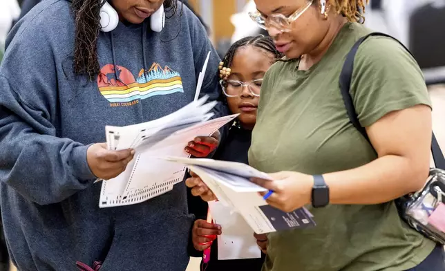 Voters look over their ballots on Election Day in Oakland, Calif., Tuesday, Nov. 5, 2024. (AP Photo/Noah Berger)