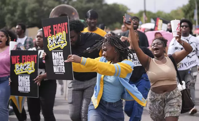 Students march and dance to a campus polling place on Election Day at Southern University in Baton Rouge, La., Tuesday, Nov. 5, 2024. (AP Photo/Gerald Herbert)