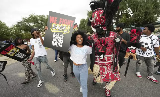 Students and a member of the Zulu Tramps march to a campus polling place on Election Day at Southern University in Baton Rouge, La., Tuesday, Nov. 5, 2024. (AP Photo/Gerald Herbert)