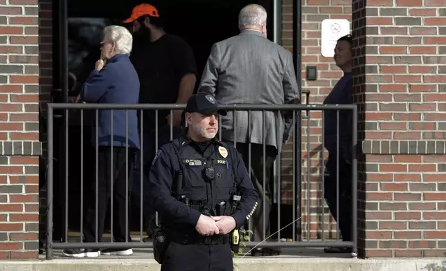 Lt. Wayne Clifford stands outside a polling location on Election Day, at the Green Ladle, High School Campus, Tuesday, Nov. 5, 2024 in Lewiston, Maine. (AP Photo/Joel Page)