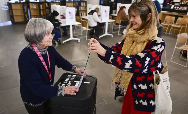 Kirsten Kearse, right, casts her ballot at the Missoula Public Library in Missoula, Mont., on Election Day, Tuesday, Nov. 5, 2024. (AP Photo/Tommy Martino)