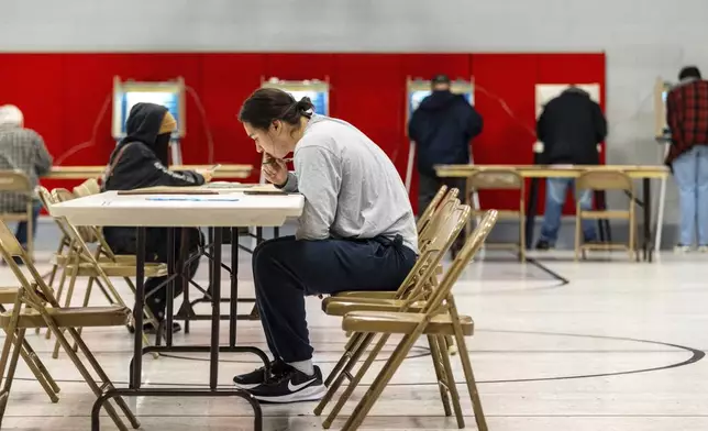 Nikolas Cardenas-Vazquez fills out his ballot inside the gym at Saints Peter &amp; Paul School in Omaha, Neb., on Election Day, Tuesday, Nov. 5, 2024. (Chris Machian/Omaha World-Herald via AP)