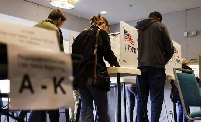 Voters, including Olivia DeBoer, center, fill out their ballots at a Holiday Inn Express and Suites in Omaha, Neb., on Election Day, Tuesday, Nov. 5, 2024. (Nikos Frazier/Omaha World-Herald via AP)