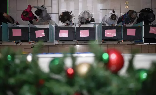 People vote at a shopping mall, Tuesday, Nov. 5, 2024, in Las Vegas. (AP Photo/John Locher)