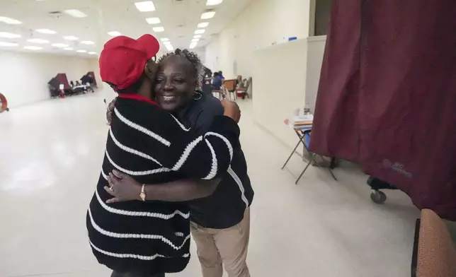 Precinct commissioner Lula Joseph, left, hugs Deneen Surtain after she cast her vote at the Household of Faith Church in New Orleans on Election Day, Tuesday, Nov. 5, 2024. (AP Photo/Gerald Herbert)