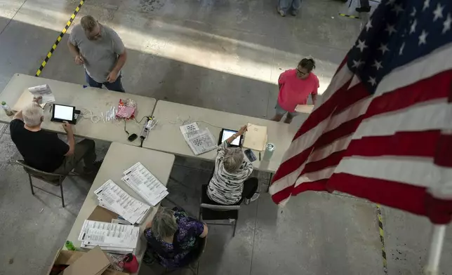 Voters check in as they arrive to vote at the Pleasant Township Fire Department on Election Day, Tuesday, Nov. 5, 2024, in Catawba, Ohio. (AP Photo/Carolyn Kaster)