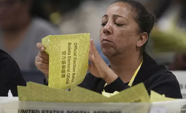 An election worker processes mail-in ballots for the 2024 General Election at the Philadelphia Election Warehouse, Tuesday, Nov. 5, 2024, in Philadelphia. (AP Photo/Matt Rourke)