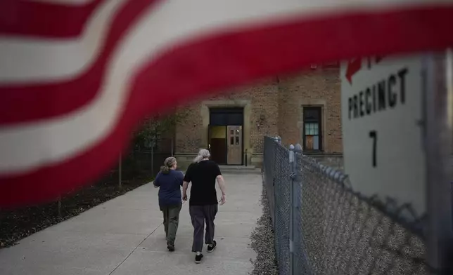 People arrive at a polling place, Tuesday, Nov. 5, 2024, in Dearborn, Mich. (AP Photo/Charlie Neibergall)