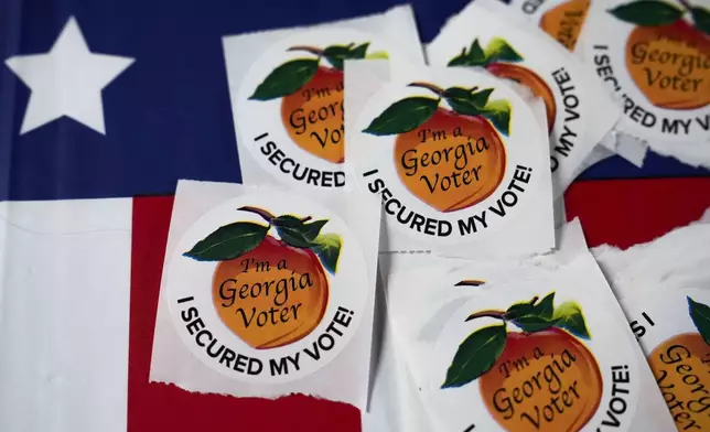 Stickers sit on a table inside a polling place, Tuesday, Nov. 5, 2024, in Atlanta. (AP Photo/Brynn Anderson)