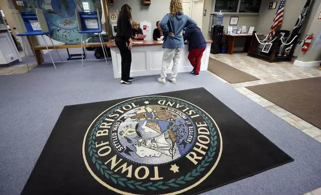 A woman registers for a provisional ballot on Election Day, Tuesday, Nov. 5, 2024, at the Town Hall in Bristol, R.I. (AP Photo/Michael Dwyer)