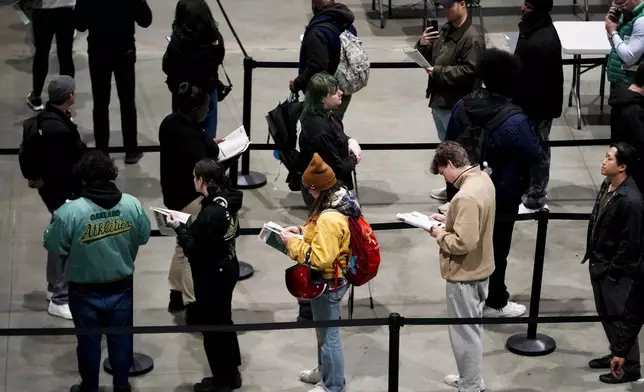 Voters wait in line to register or pick up their ballots at Lumen Field Event Center on Election Day, Tuesday, Nov. 5, 2024, in Seattle. (AP Photo/Lindsey Wasson)