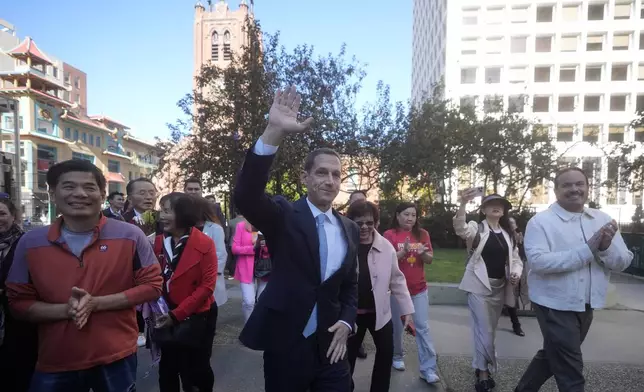 Daniel Lurie waves as he arrives at a news conference in San Francisco, Friday, Nov. 8, 2024. (AP Photo/Jeff Chiu)