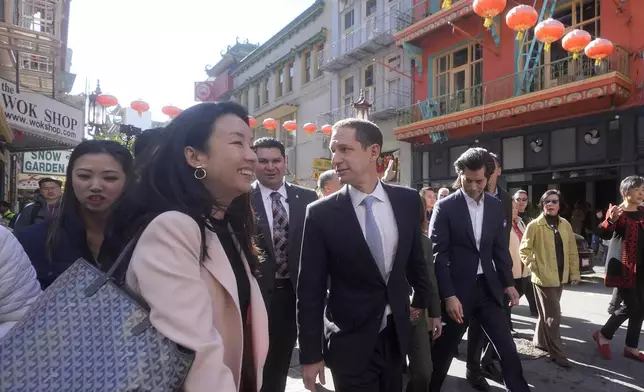 San Francisco mayoral candidate Daniel Lurie, middle, tours businesses as he walks through Chinatown in San Francisco, Friday, Nov. 8, 2024. (AP Photo/Jeff Chiu)