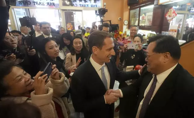 San Francisco mayoral candidate Daniel Lurie, middle, greets Wing Pau, manager of Far East Cafe restaurant, as he walks through Chinatown in San Francisco, Friday, Nov. 8, 2024. (AP Photo/Jeff Chiu)