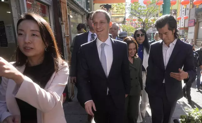 San Francisco mayoral candidate Daniel Lurie, middle, and his wife, Becca Prowda, middle right, walk through Chinatown in San Francisco, Friday, Nov. 8, 2024. (AP Photo/Jeff Chiu)