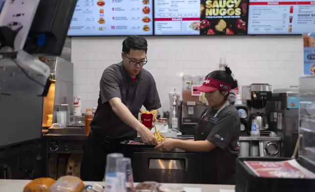 FILE - Lawrence Cheng, left, whose family owns seven Wendy's locations south of Los Angeles, works with part-time employee Adriana Ruiz at his Wendy's restaurant in Fountain Valley, Calif., June 20, 2024. (AP Photo/Jae C. Hong,File)