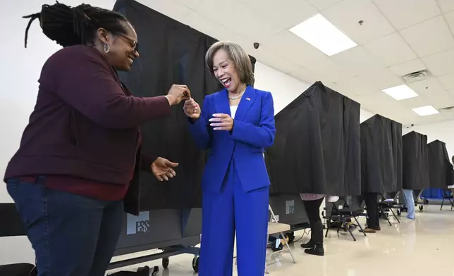 Rep. Lisa Blunt Rochester, D-Del, right, receives a sticker from Tracey Dixon after voting during early voting, Sunday, Nov. 3, 2024, in Wilmington, Del. (AP Photo/Gail Burton)