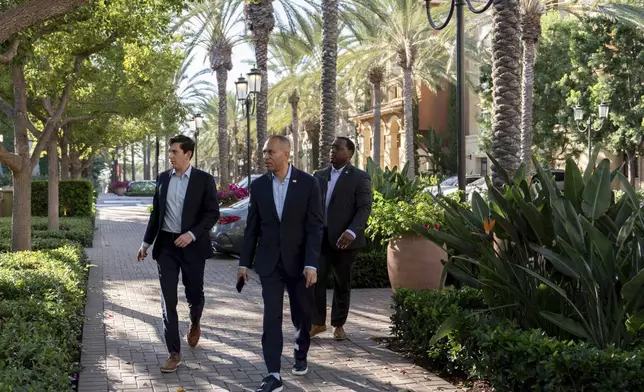 House Minority Leader Hakeem Jeffries, D-N.Y., center, arrives for an interview with The Associated Press, Saturday, Oct. 12, 2024, in Irvine, Calif. (AP Photo/Julia Demaree Nikhinson)