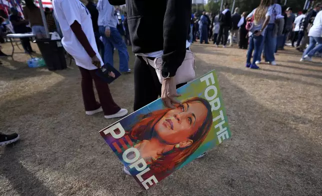 A supporter holds a sign for Democratic presidential nominee Vice President Kamala Harris at a campaign rally outside the Atlanta Civic Center, Saturday, Nov. 2, 2024. (AP Photo/Brynn Anderson)