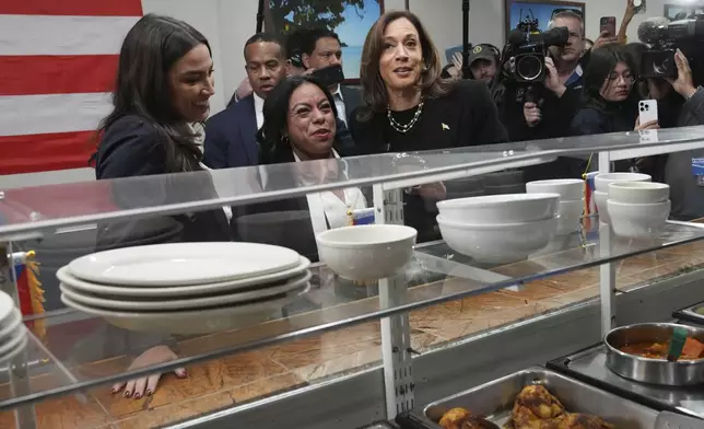 Democratic presidential nominee Vice President Kamala Harris, from right, visits Old San Juan Cafe restaurant with restaurant owner Diana de La Rosa and Rep. Alexandria Ocasio-Cortez, D-N.Y., during a campaign stop in Reading, Pa., Monday, Nov. 4, 2024. (AP Photo/Jacquelyn Martin)