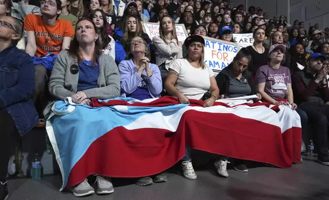 Attendees holding the flag of Puerto Rico listen as Allentown, Pa. Mayor Matt Tuerk speaks during a campaign rally for Democratic presidential nominee Vice President Kamala Harris in Memorial Hall at Muhlenberg College in Allentown, Pa., Monday, Nov. 4, 2024. (AP Photo/Susan Walsh)