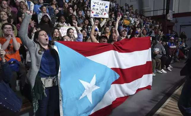 Attendees holding the flag of Puerto Rico cheer as Allentown, Pa. Mayor Matt Tuerk speaks during a campaign rally for Democratic presidential nominee Vice President Kamala Harris in Memorial Hall at Muhlenberg College in Allentown, Pa., Monday, Nov. 4, 2024. (AP Photo/Susan Walsh)